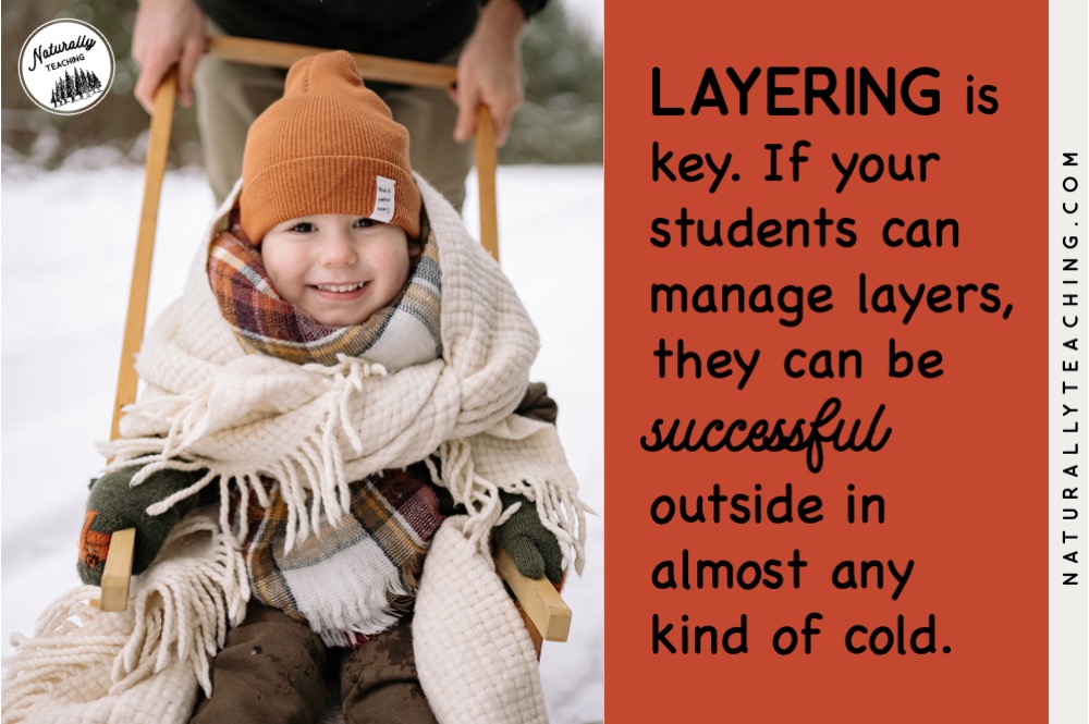 This boy on a sled is covered in many layers of winter gear which will help him stay warm in the snow.